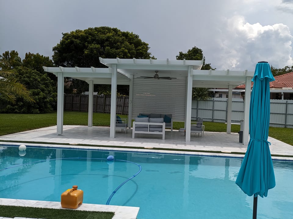 Diseño tradicional imitación madera con techo sólido y vigas con remates curvos decorativos (decorative rafter tails), ideal para crear un espacio de sombra junto a la piscina, en patios y jardines.