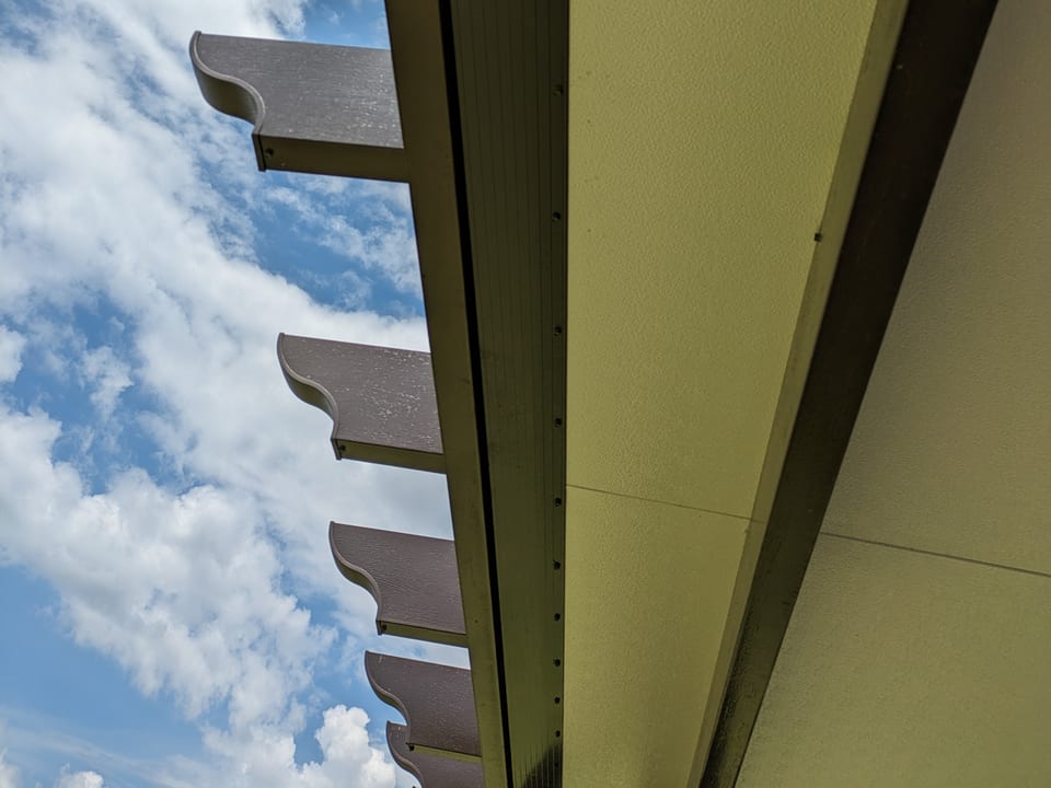 Insulated patio roof in bronze color, L-shaped structure